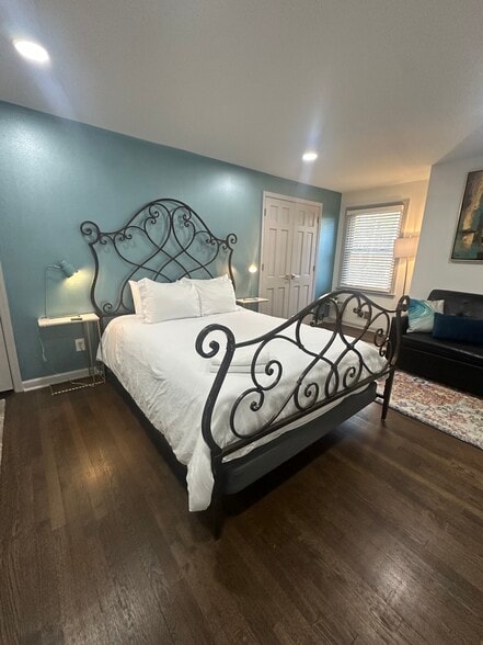 Upstairs bedroom featuring a queen-sized iron bed — classic style and cozy comfort. - 5460 Scofield Rd
