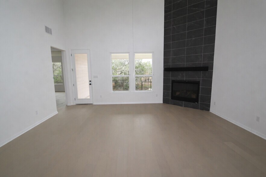 Spacious two-story living room with soaring ceilings, abundant natural light. - 517 Moonlit Stream Pass