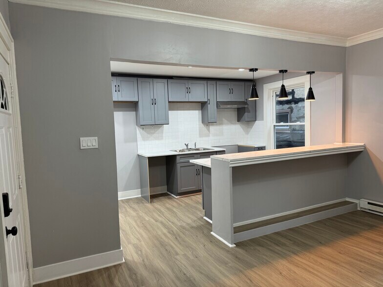 Open Concept Kitchen & Dining Area- Modern open kitchen with bar seating, ideal for entertaining. - 898-902 Portland Ave