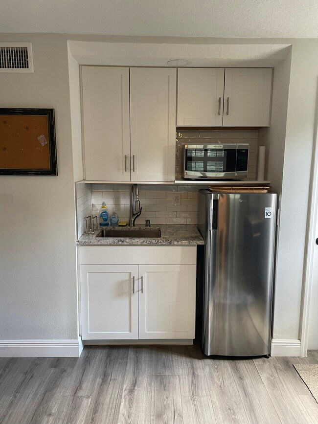 Kitchenette with fridge/freezer, microwave and kitchen island. - 1430 Lake Weldona Dr