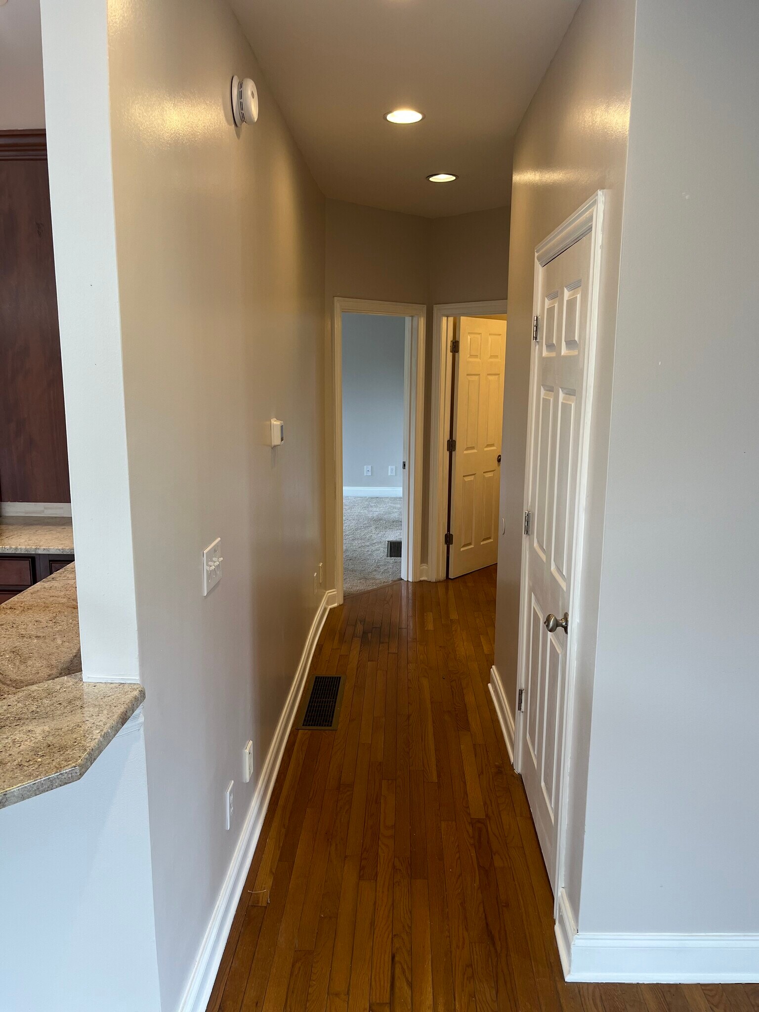 First Floor Hallway Includes The Stairs, Laundry, 1/2 Bath and Primary Bedroom. - 393 Hays Blvd
