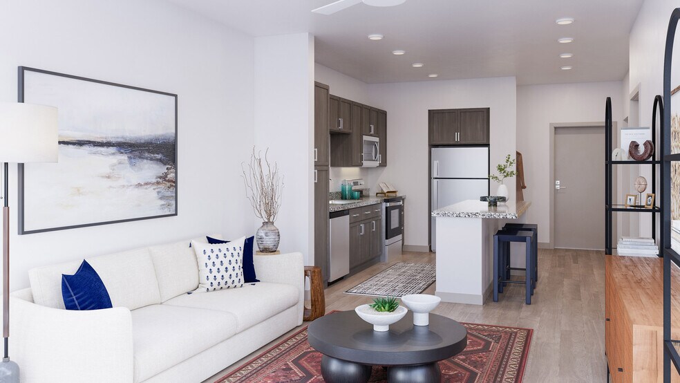 Modern open concept apartment with living room, kitchen island, neutral finishes, and contemporary furnishings for everyday comfort - Mesquite Trails at Brooks - A 55+ Community