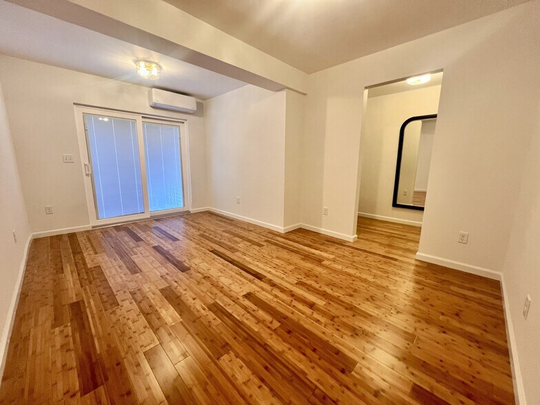 Bedroom with new bamboo flooring and a nice sized closet/dressing room with sliders to patio. - 352 S Main St