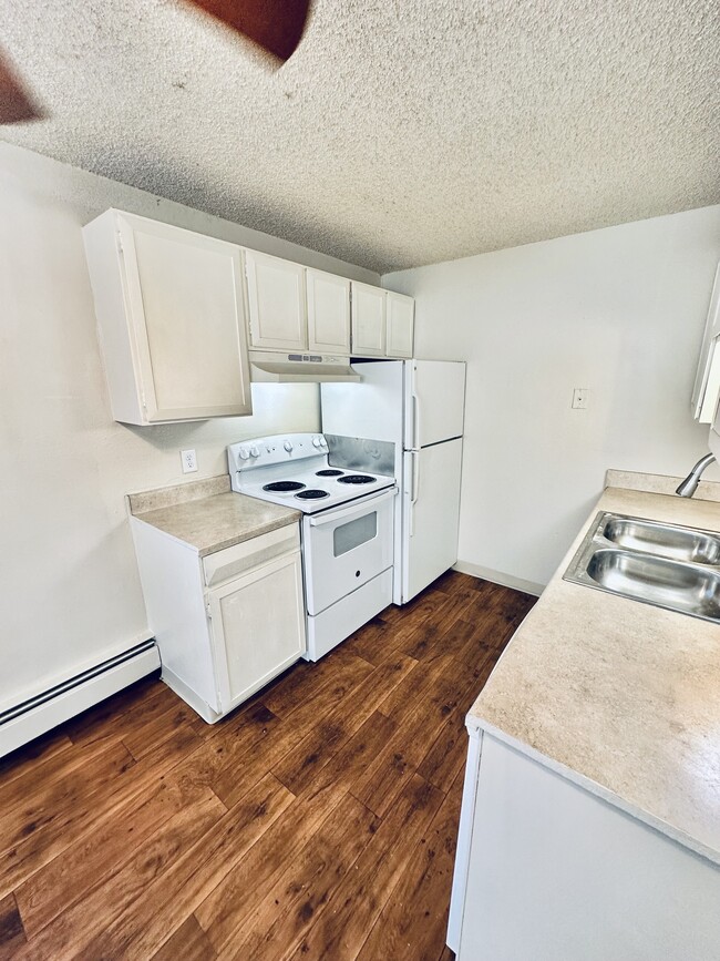 Explore this inviting kitchen space, perfect for cooking and entertaining. - Hawk Point Apartments