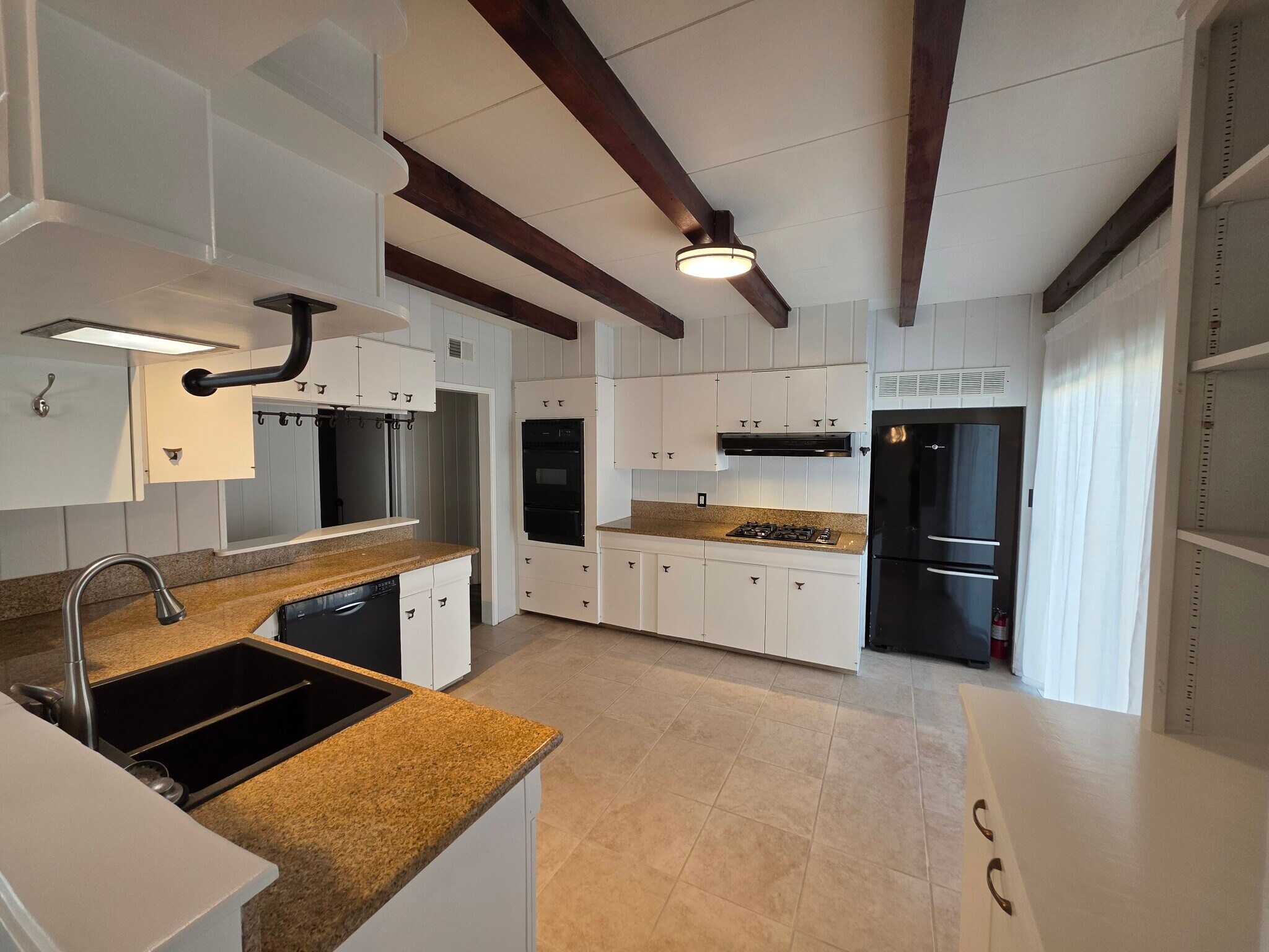 View into kitchen from dining room. On the right is a sliding door to the side yard. - 456 E Indian Rock Rd