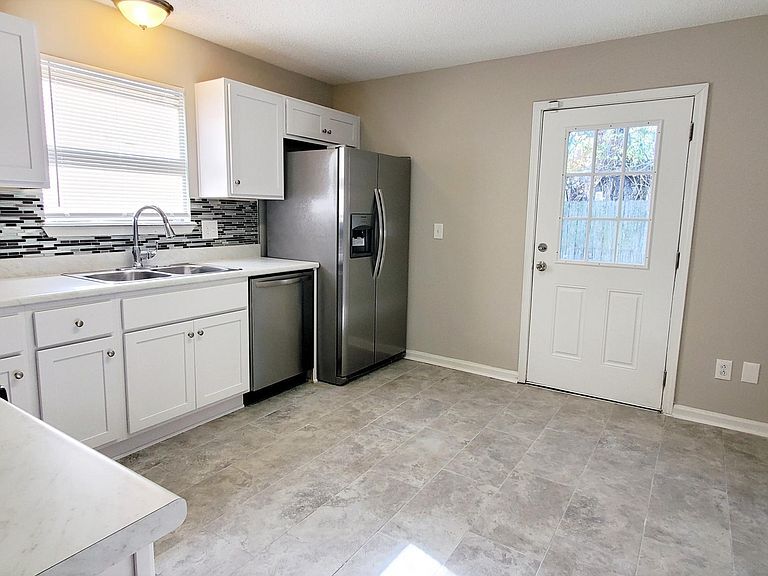 Kitchen access to private concrete patio and fenced yard with storage shed. - 1300 Bay Hill Blvd.