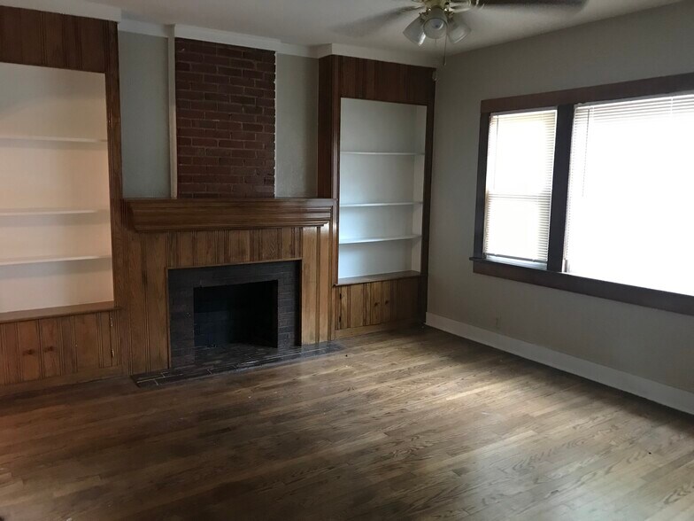 Living area with faux fireplace and bookshelves. New windows throughout. - 512 NW 31st St