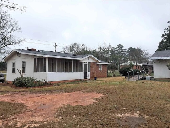 back yard partially fenced with large storage shed and deck - 407 Collins Ave