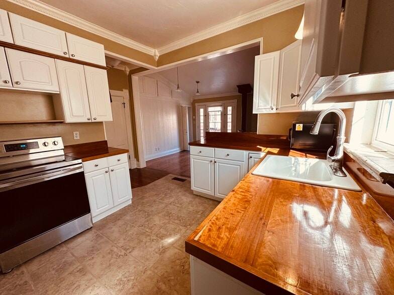 Modern, open kitchen off of back living room with wood-burning fireplace. - 812 E Cache La Poudre St