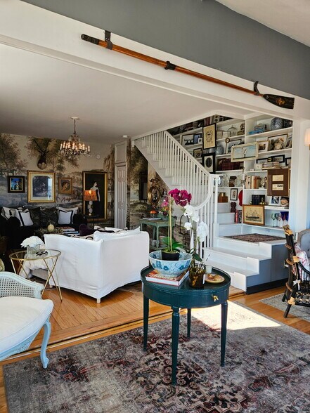 living room with staircase book shelve display - 1301 Rogers Rd