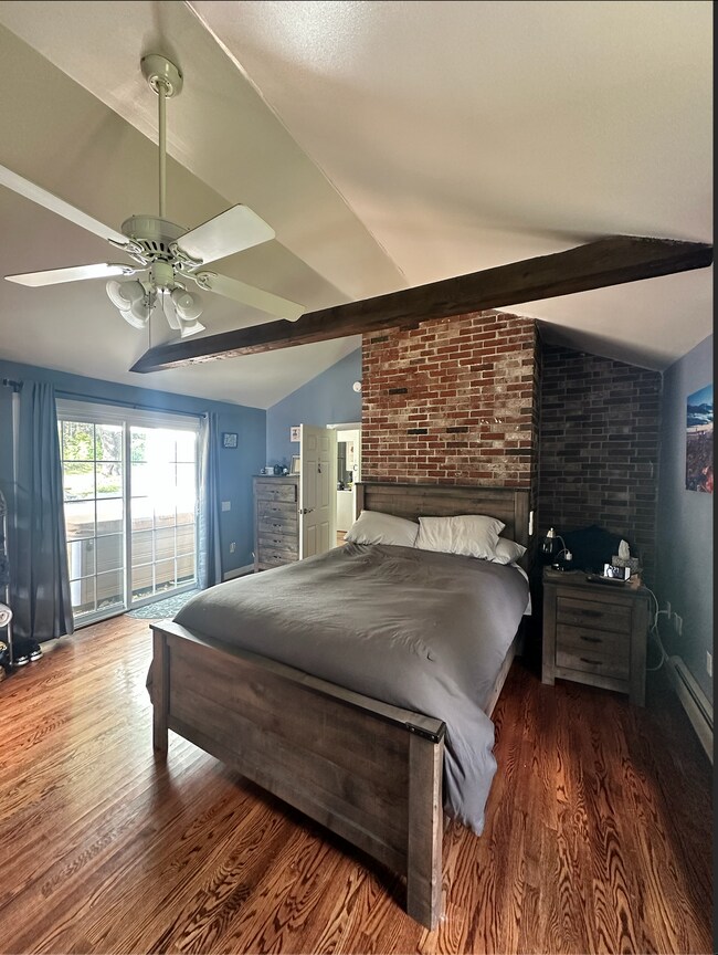 Master bedroom featuring vaulted ceilings, exposed brick, and exposed wood beams - 1138 Western Ave