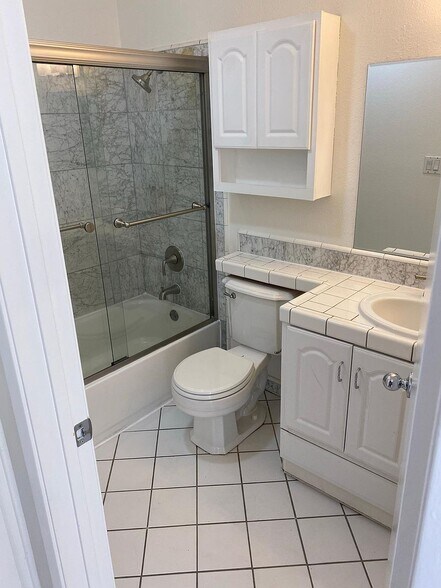 Full bathroom with tiled floors and tub/shower - 8305 Summertime Ln