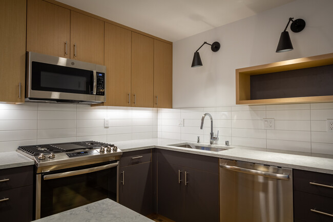 Custom cabinetry, quartz countertops, tiled backsplash, under cabinet lighting, Cedar and Moss light fixtures. Energy efficient LED lighting throughout. - 625 Malden Ave E