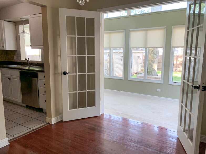 Dining area leading into bonus sunroom. - 1336 N Eagle St