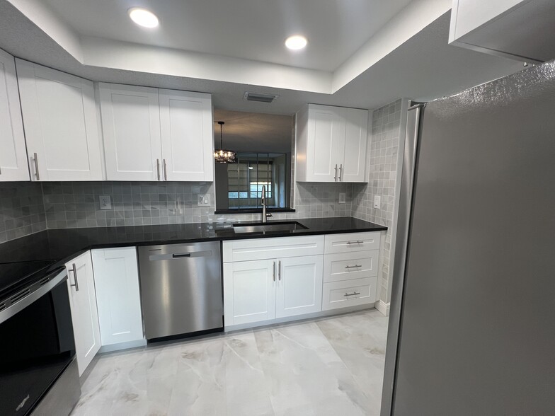 White shaker cabinets, new stainless steel appliances, and granite countertops - 1060 NW 80th Ave