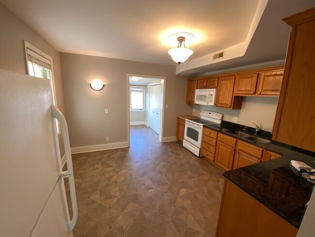 Spacious kitchen with granite countertops and eat in area - 225 N Franklin St