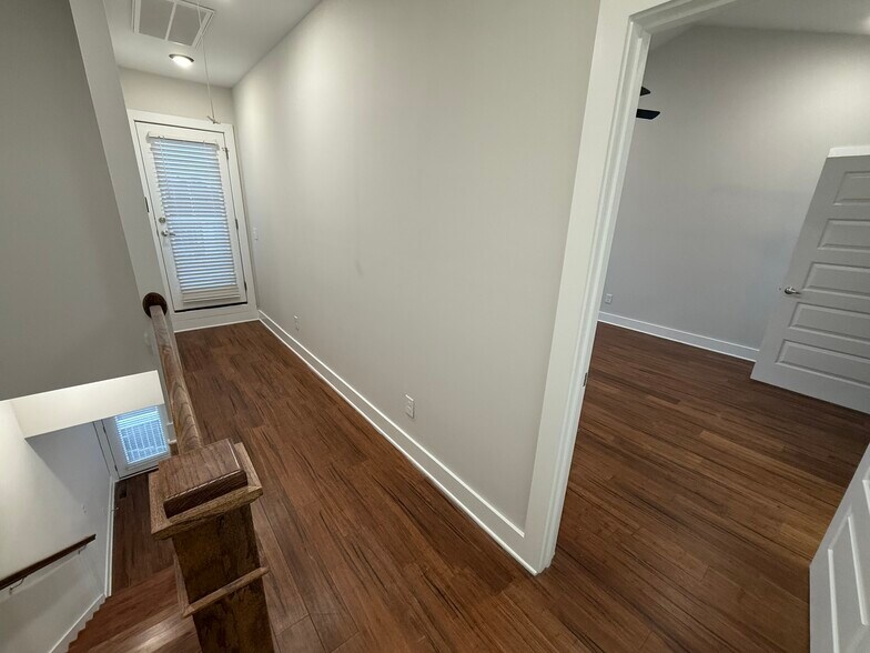 Third-Floor Landing: Connecting the primary suite, full bathroom, laundry area, and rooftop deck. - 421 Elysian Fields Rd