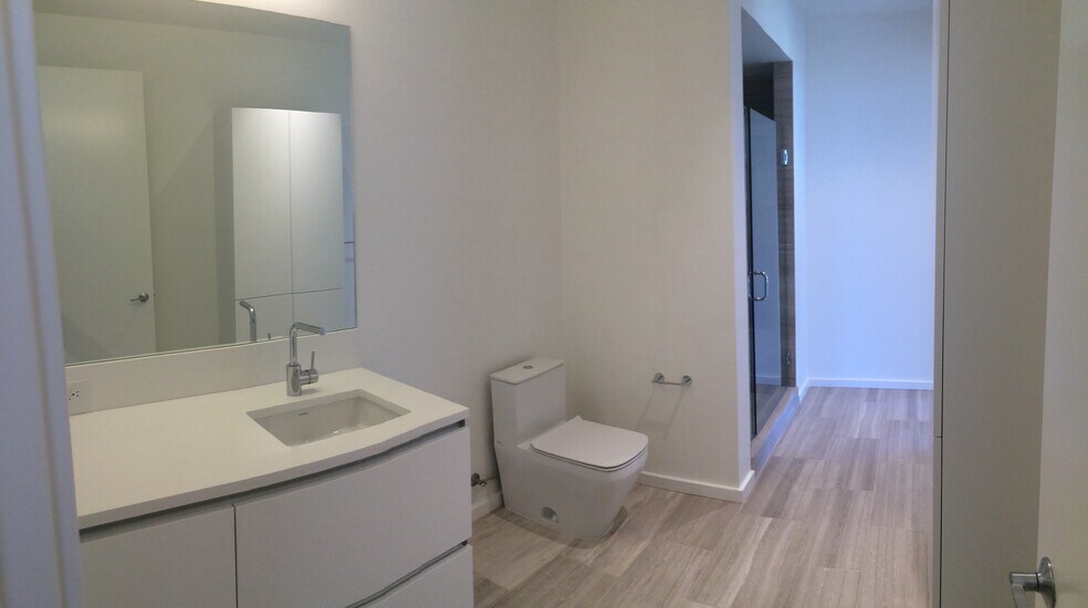 Marble and travertine tile finishes in the bathroom. Quart countertop. - 1275 NW 10th Ave
