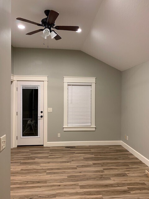 master bedroom, vaulted ceiling, ceiling fan, back door to deck with built in blind - 607 W Duncan Dr