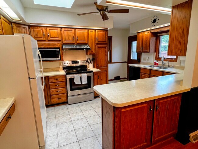 The kitchen is well-stocked for cooking and has ample storage. - 228 W Lexington Blvd