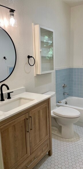 Guest bathroom with tub and vanity and built-in shelf. - 6605 Shady Lake Ln