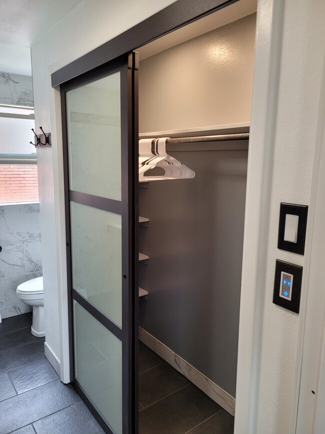 Lighted closet with hangers and shelving. - 1550 Oak Ct