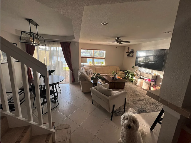 living room with fenced patio access that opens up to pond front - 1162 Imperial Lake Rd