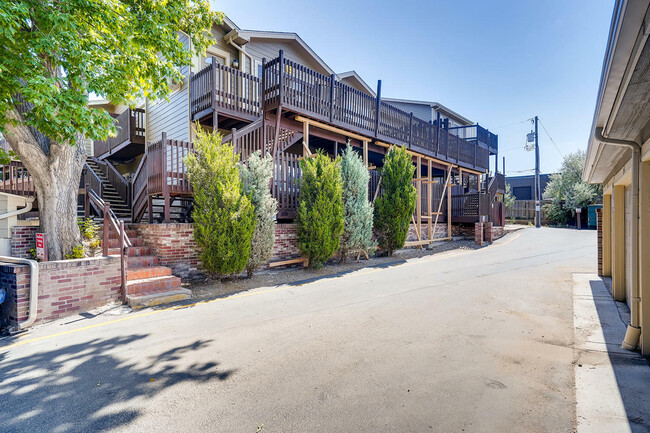 Explore this picturesque apartment building with inviting wooden balconies and verdant landscaping. - Table Mountain Townhomes