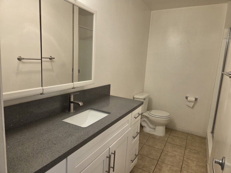 Hall bathroom with quartz countertop and Shaker cabinets - 3455 Elm Ave