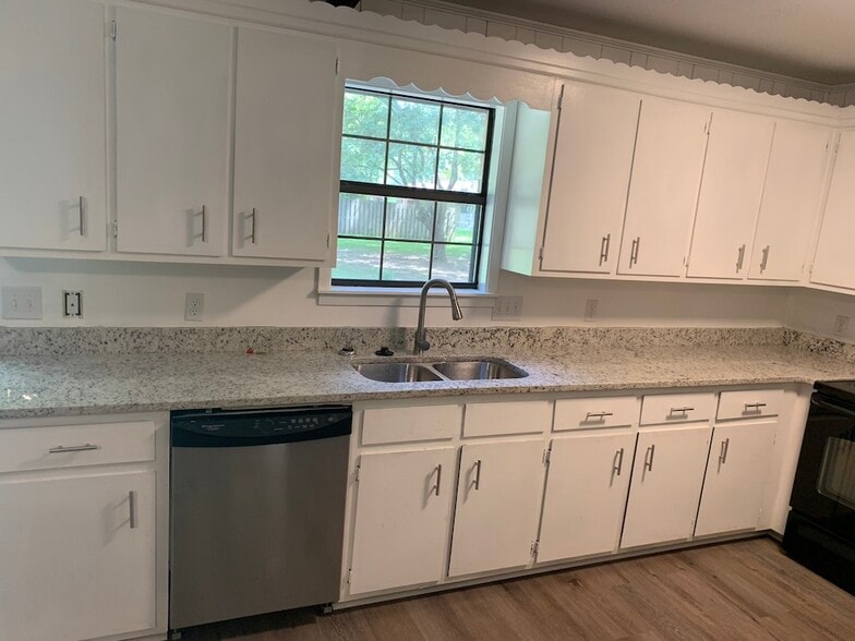 Newly remodeled kitchen with granite countertops, dish washer, oven, microwave, and refrigerator. - 1903 Ginnett Rd