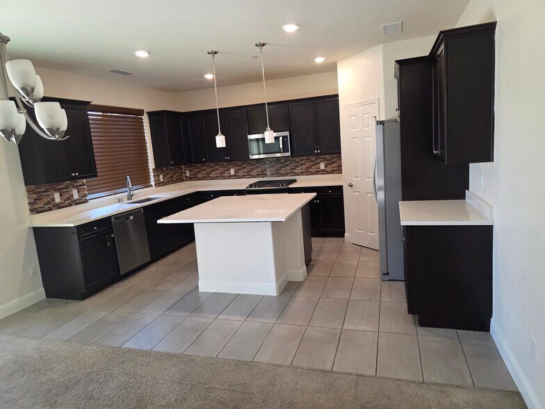 Kitchen with dishwasher, microwave, and fridge - 6193 E Homan Ave