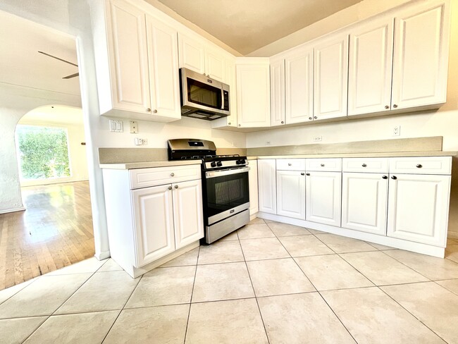Kitchen with whit cabinets, stone countertops, and dishwasher! - 545 N Vista St
