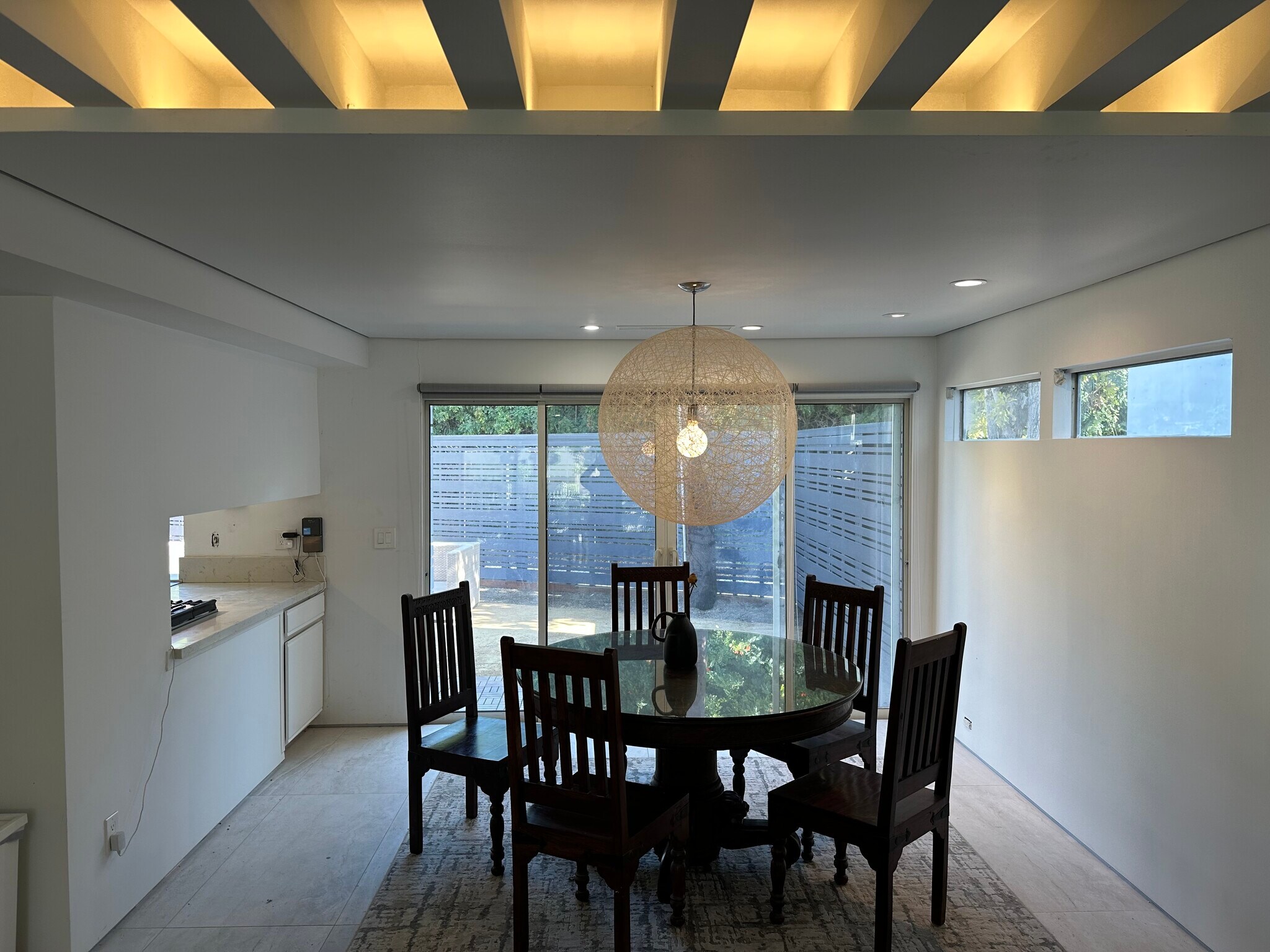 The dining area features a dramatic exposed beam ceiling with ambient uplighting. - 5214 Dawes Ave