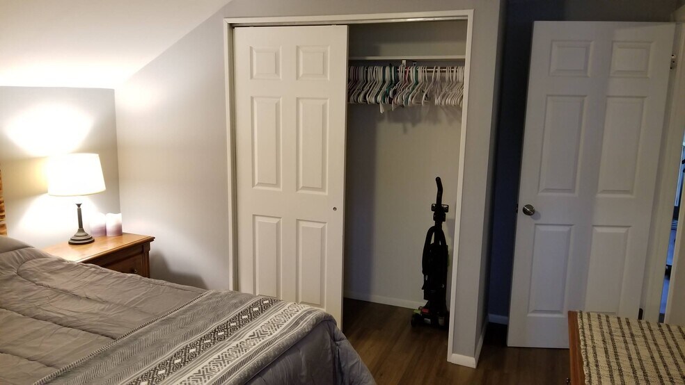 Bedroom closet with hangers and vacuum - 715 Main Street