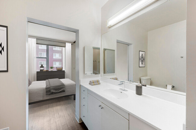 Renovated Package I bath with white cultured marble countertops, white cabinetry, and hard surface flooring - AVA H Street