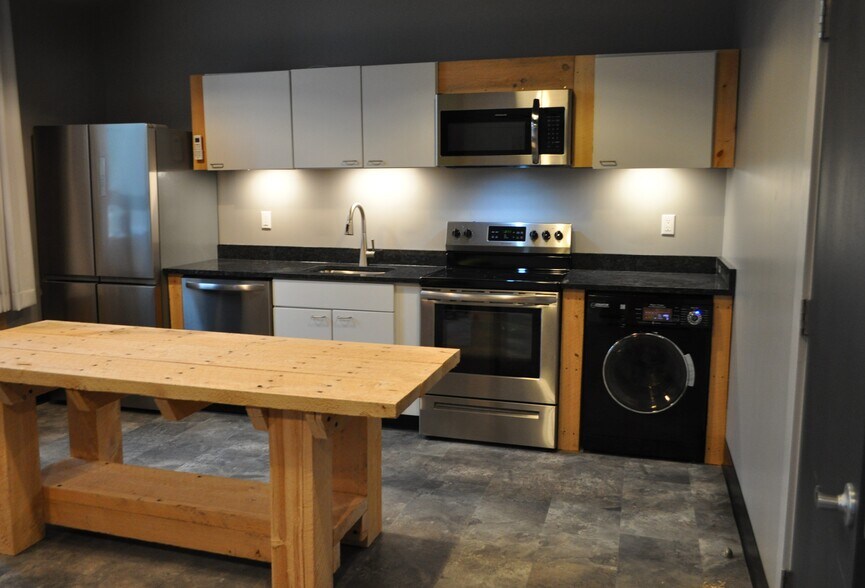 Kitchen with Stainless Appliances, Solid Surface countertop, W/D combo unit and island - 208 W Broadway St