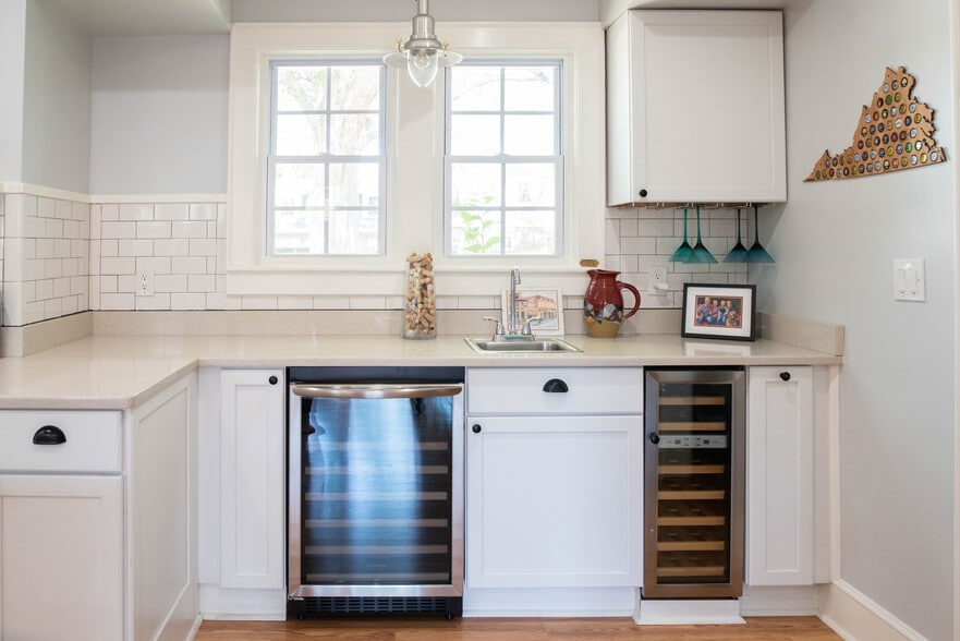 Wet Bar in Kitchen. Wine & beverage fridges, sink, and built-in stemmed glassware hanging rack. - 417 E Government Ave