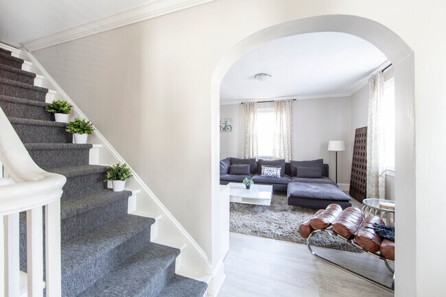 Comfortable bright living room. Stairs are a cool decorative accent. There is no second floor.. - 1111 Herrin Ave