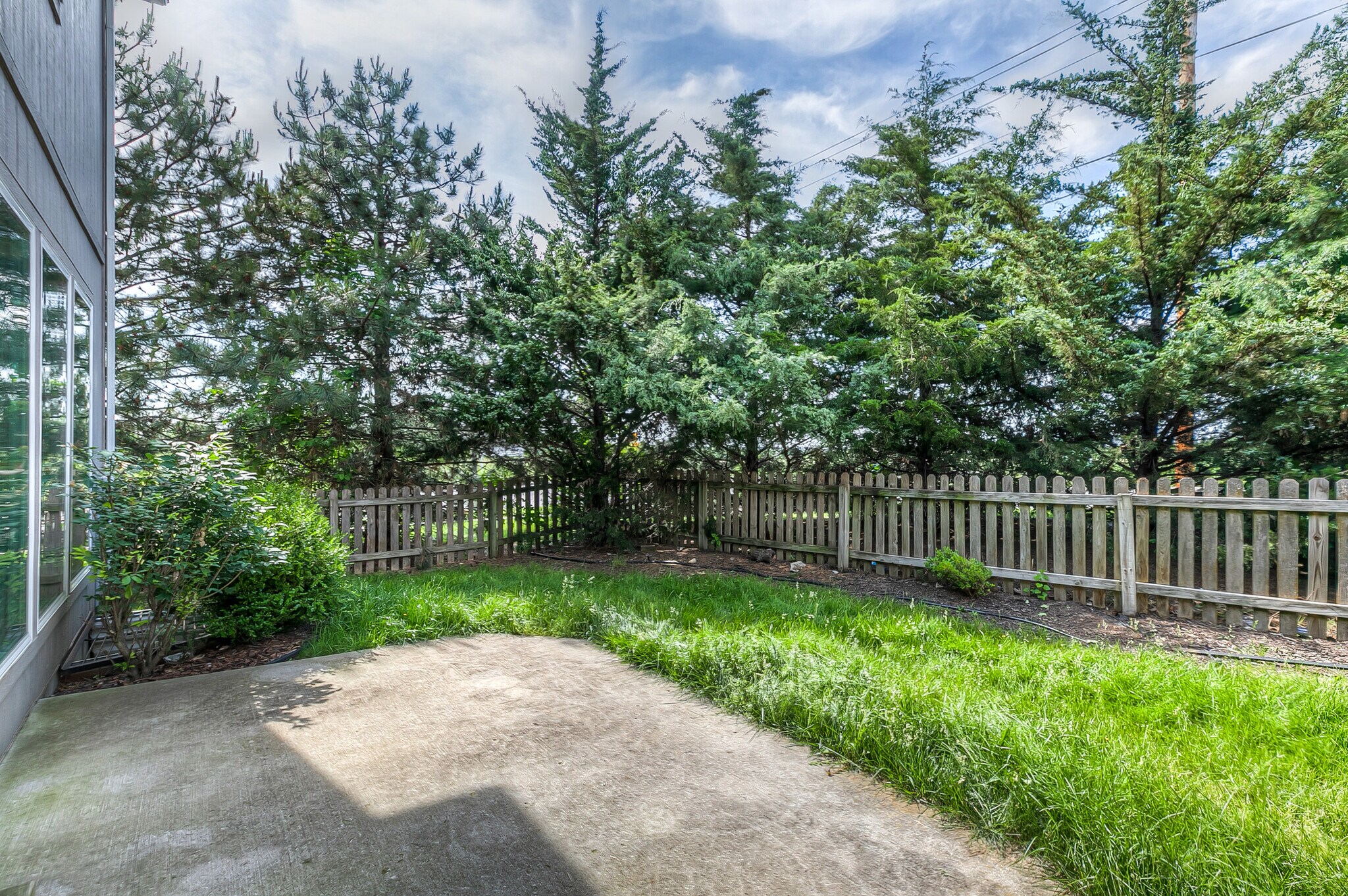back yard with patio, fence, and treed for privacy - 22810 West 71st Terrace