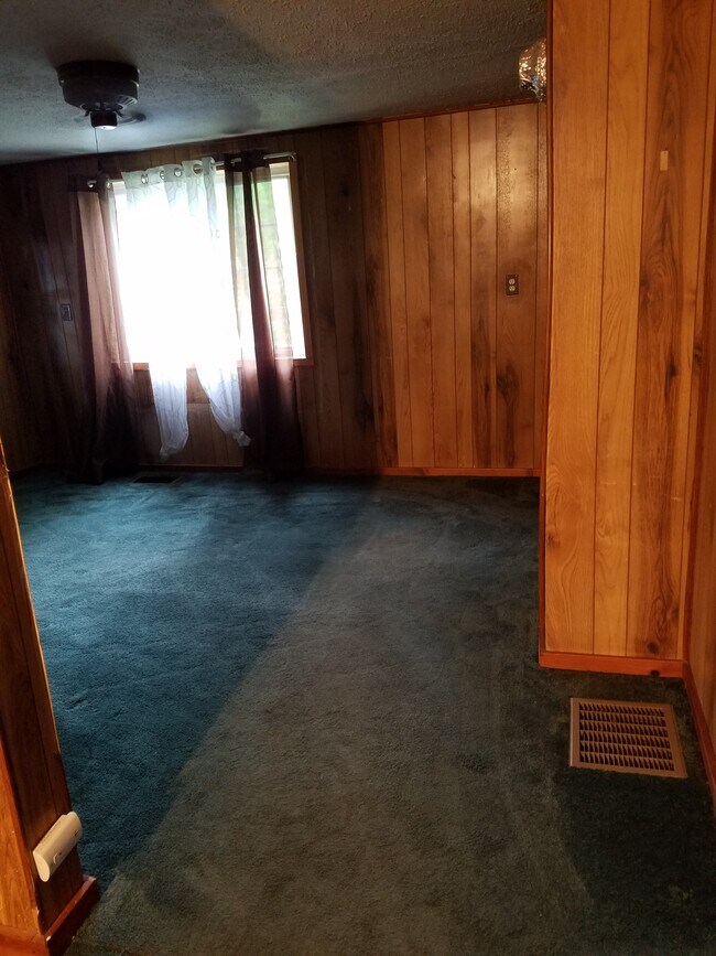 Livingroom, south wall. Wall to wall carpeting, three windows, ceiling fan. - 15 Goodrich St