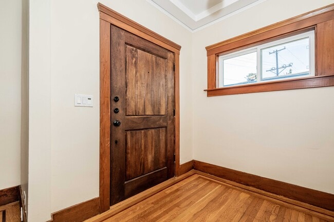 Living room with natural light, built ins, entry closet and security system. - 431 Athol Ave