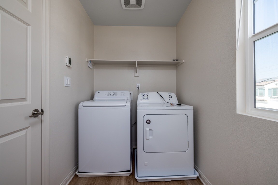 Upstairs laundry room with natural light, featuring a washer, dryer - 26549 Brightstone Dr