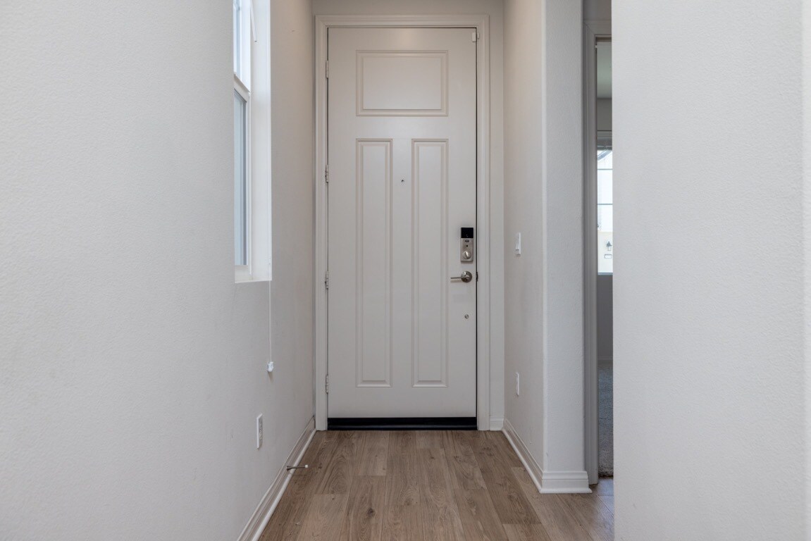 Bright and welcoming entryway with laminate flooring and modern white door, creating a clean - 26549 Brightstone Dr