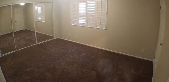 Master bedroom with wall-to-wall mirrored closet . NOTE: Carpet shown is not actual color. New car - 14365 Foothill Blvd