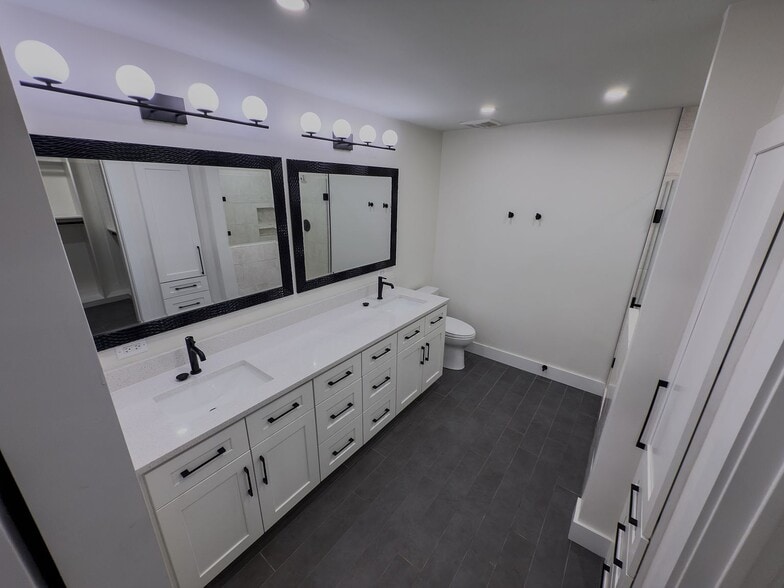 Main bathroom wide view with double vanity, toilet, and step-in shower - 2006 Candle Ct