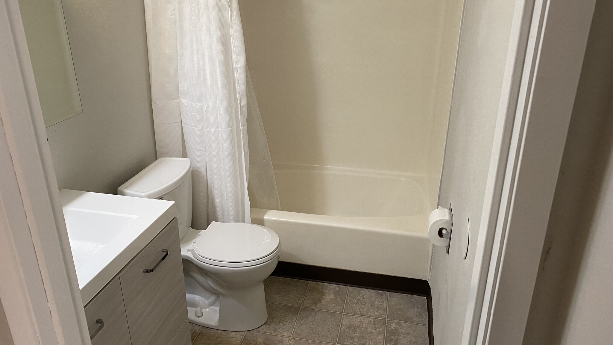 Bathroom - fiberglass tub/shower, single sink vanity, vinyl flooring, medicine cabinet bi-fold. - 3150 Maryland St