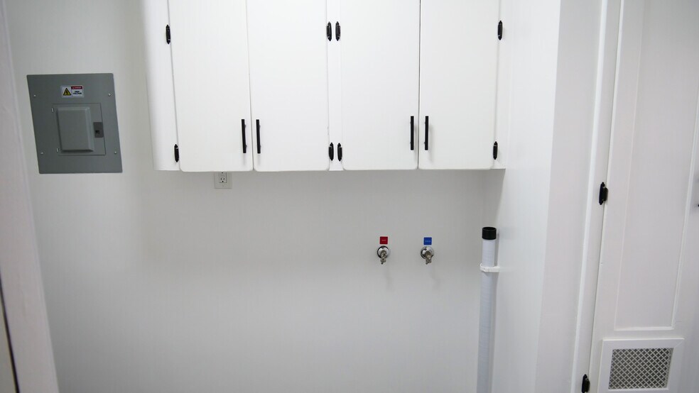 Laundry room with hookups and overhead storage. Original 1950s appeal with a touch of 2026. - 259 E Puente St