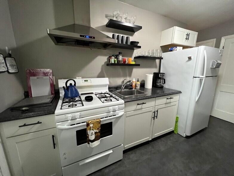 Full kitchen with coffee pot, pots, pans, microwave, toaster, and dishes. - 4622 Cass St