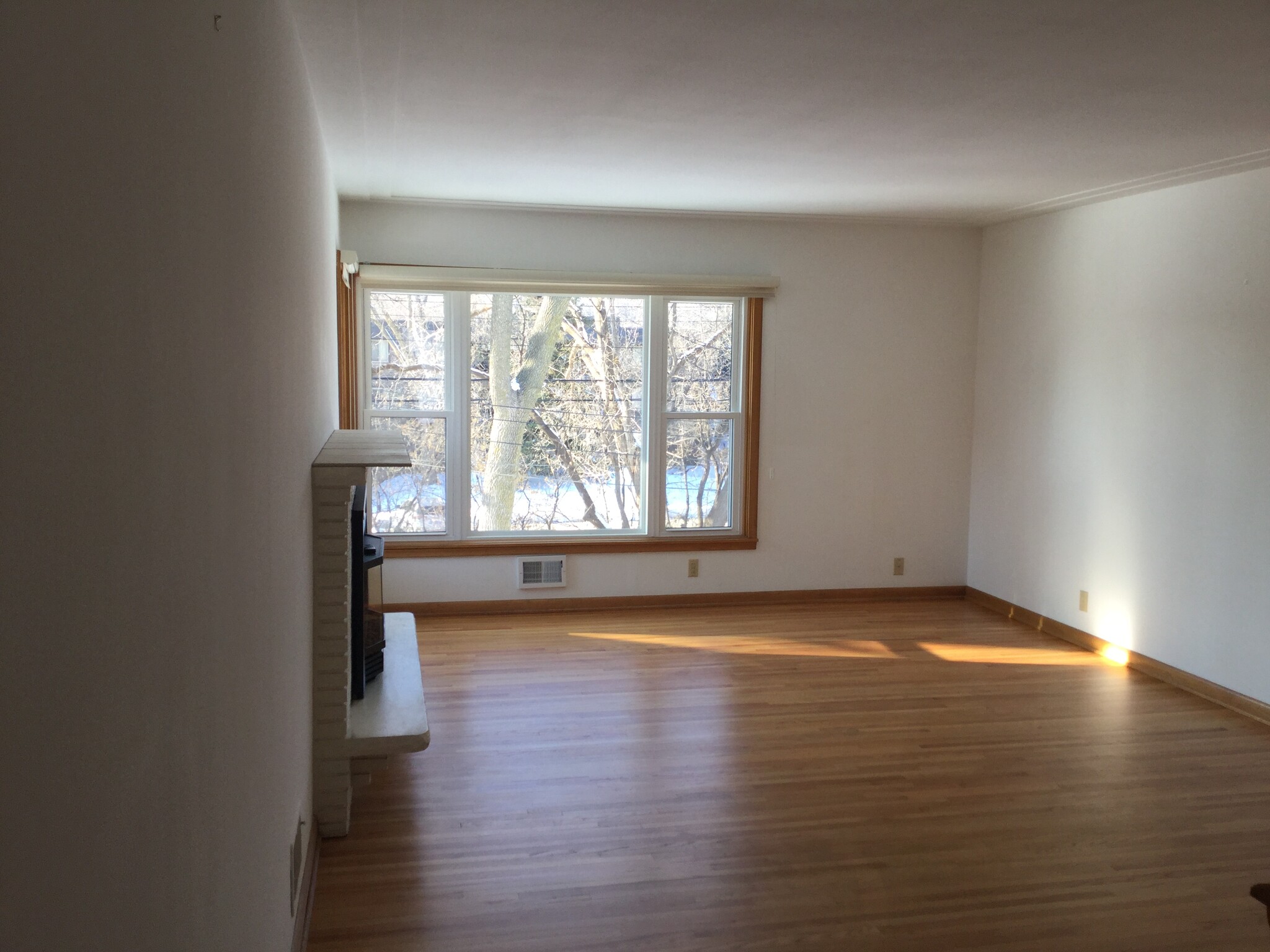 Light filled living room with freshly refinished hardwood floors and gas fireplace - 5206 Grandview Ln