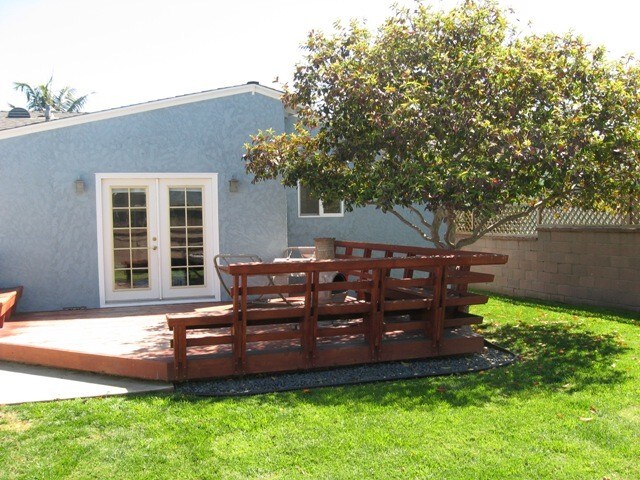 Custom-built redwood deck with seating, space for a chiminea, and a mature guava tree. - 14911 Fonthill Ave